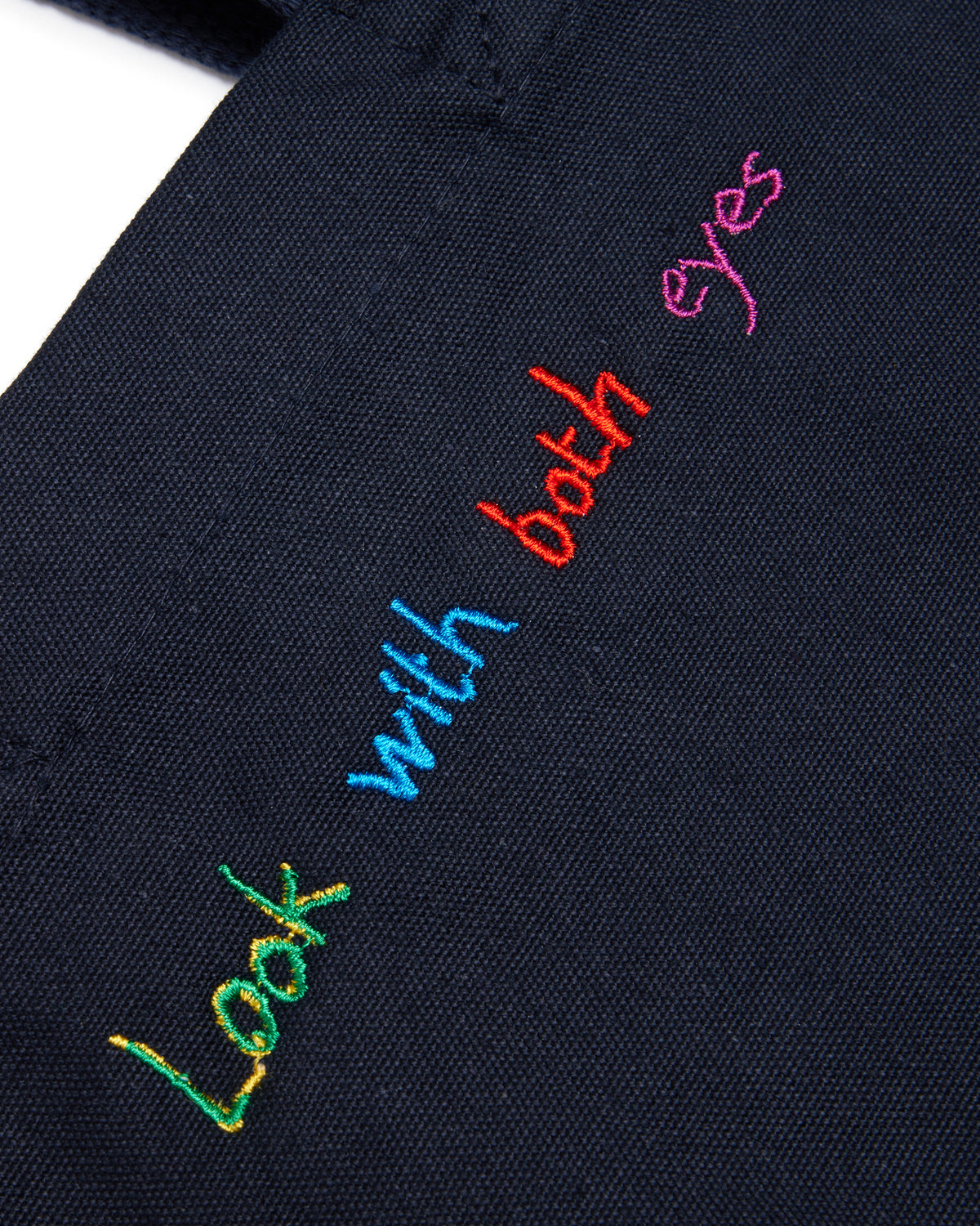 Navy blue fabric with colorful embroidered text on a white background