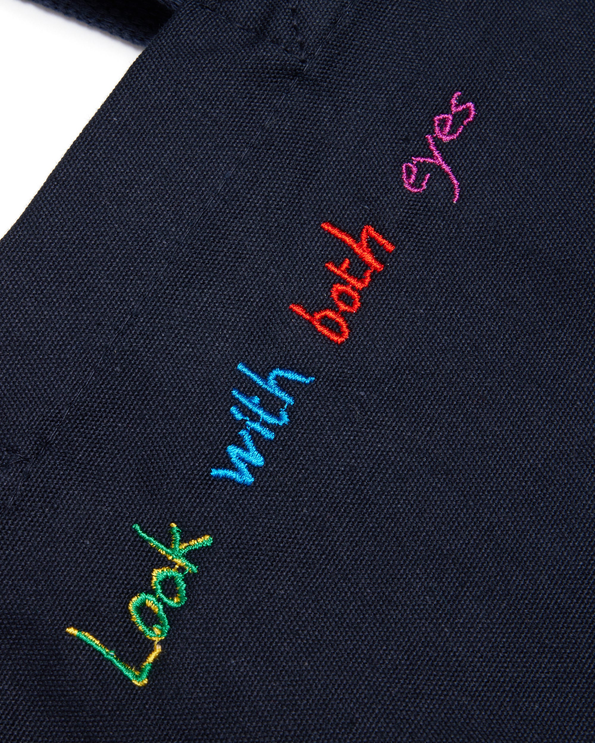 Navy blue fabric with colorful embroidered text on a white background